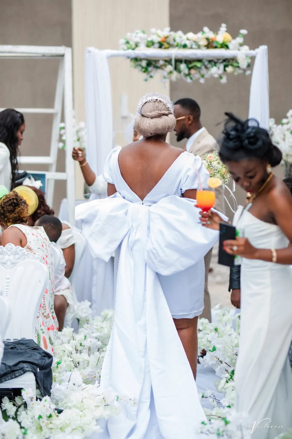A bride seen from behind, a large white bow at her back.